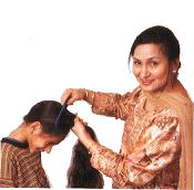 Mother combing her young sons hair